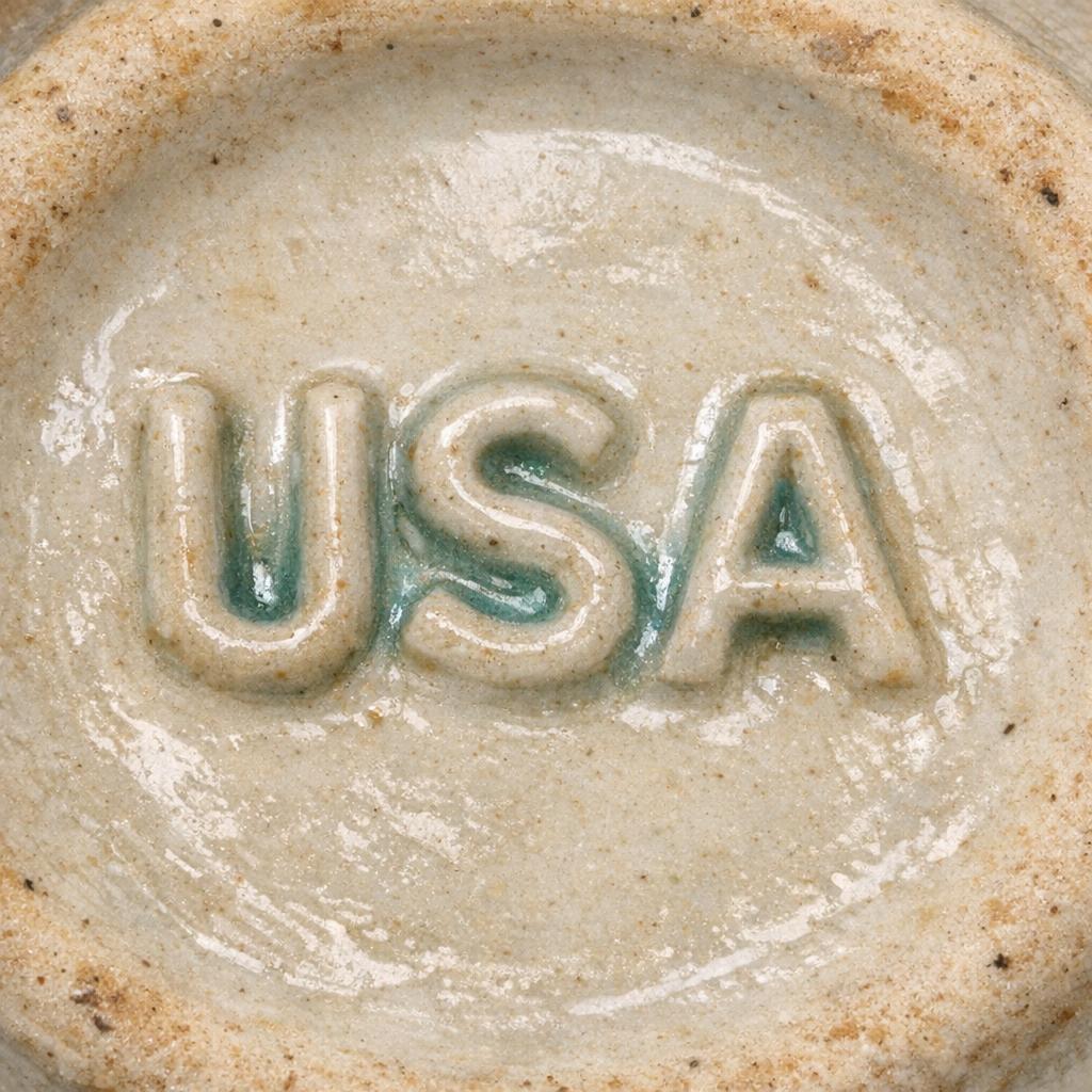 USA McCoy pottery stamp mark on a glazed underside showing slight glaze pooling in the stamped letters