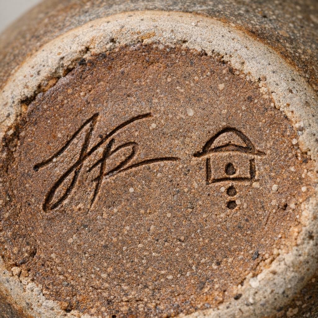 Incised studio signature on the base of a handmade pottery vase