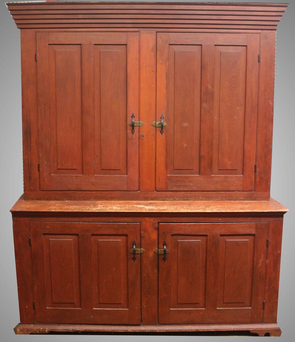 Auction comp thumbnail for TWC – Furniture: Antique wall cupboard in old red – a nice softwood two-piece step-back cupboard with matching double-blind doors top & bottom with raised panel doors; natural shelf interior @base/pinted red interior @top; five step-out molding @t (Roan Inc. Auctioneers & Appraisers, Lot 300)