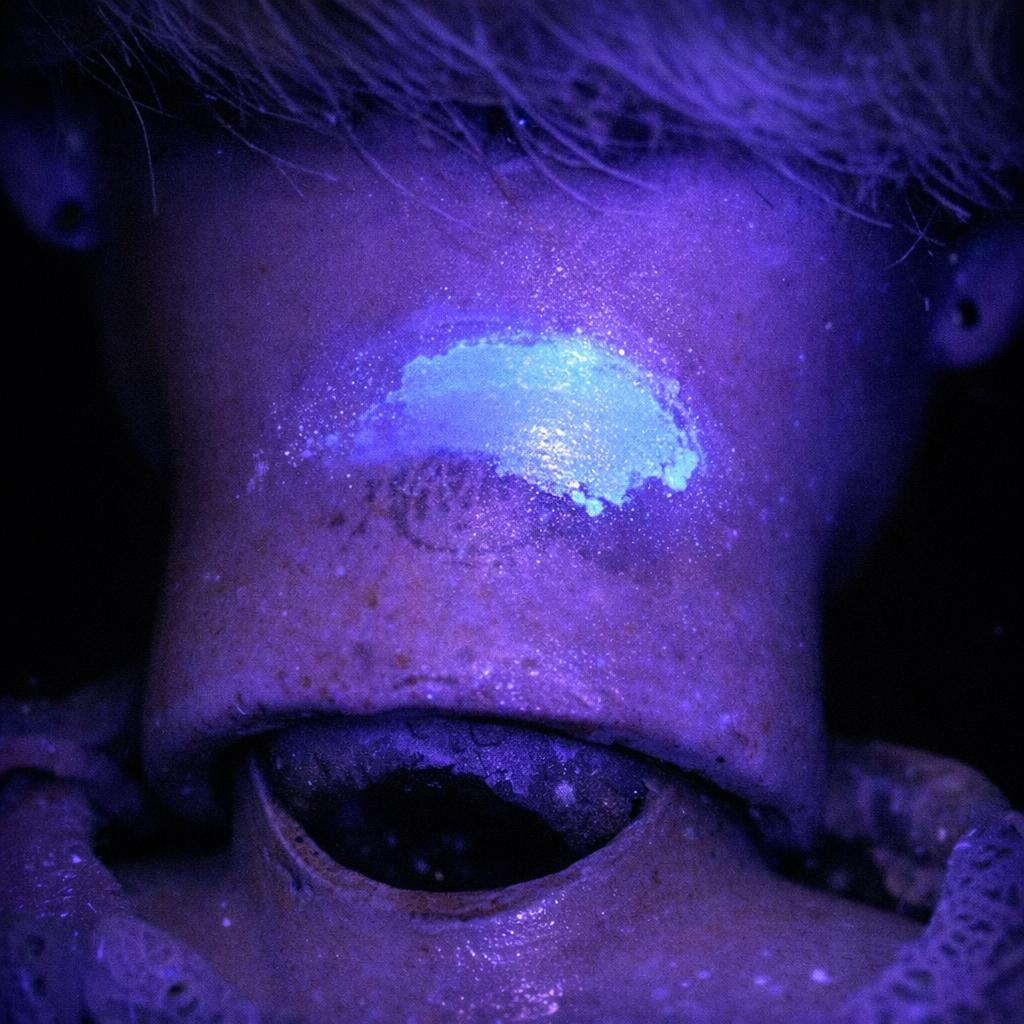 Ultraviolet light inspection showing overpaint near a doll mark