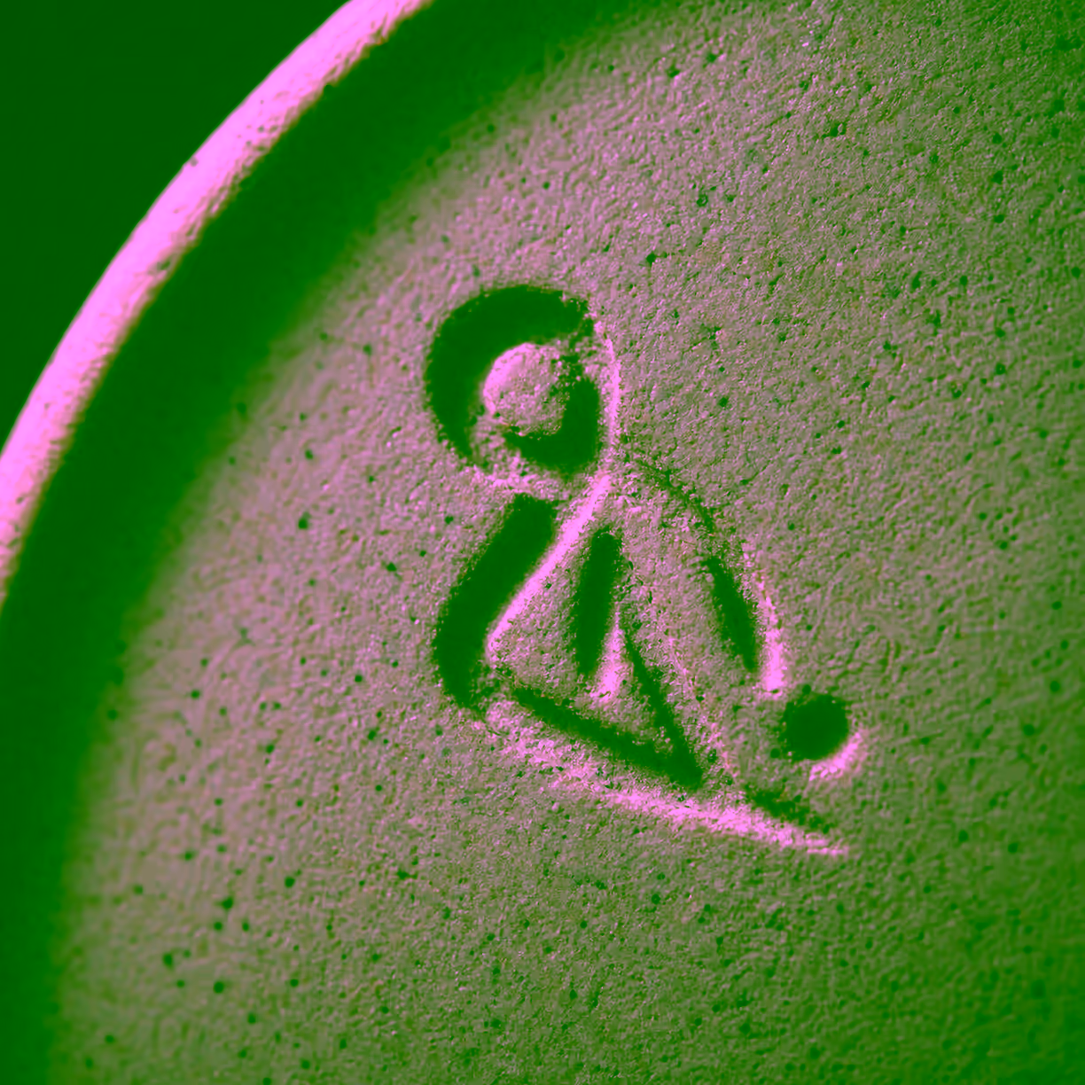 Macro photograph of a fictional abstract impressed mark in a neutral stoneware surface under low raking light.